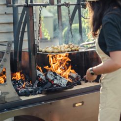 Asado Primera BBQ - Lifestyle turning potatoes katherine wheel - Firepits UK - WEB 600x600 - Lo Res
